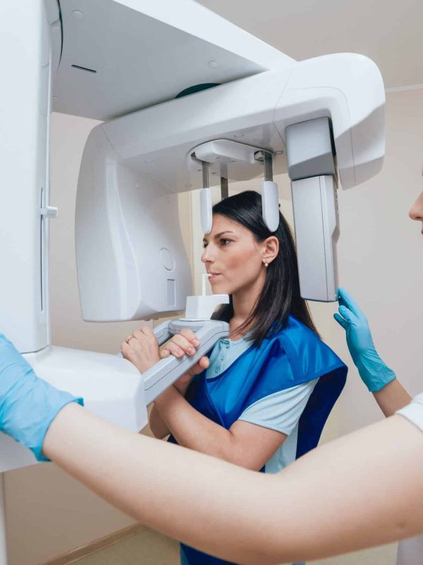 Young woman patient standing in x-ray machine. Panoramic radiography